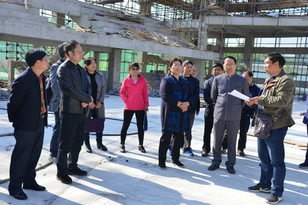 调研县民族中学在建的综合楼